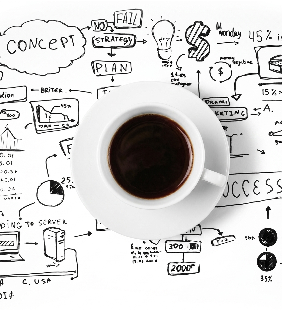 White coffee cup sitting on a brainstorming blueprint