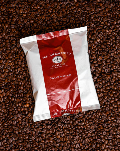 A frac pack of coarsely ground House Blend sitting on coffee beans to brew in an urn.