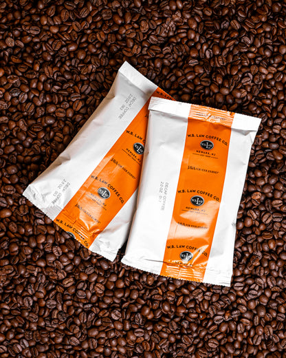 Two 2oz frac packs of ground WB Law Coffee decaf coffee perfectly batched for drip coffee brewing in your home or office.