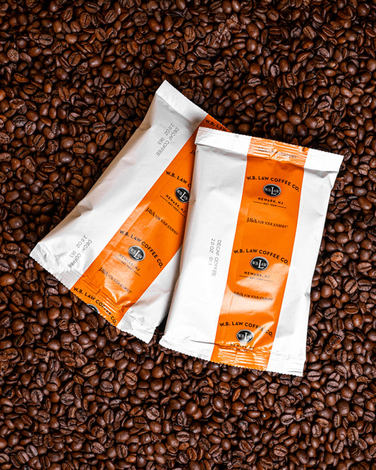 Two 2oz frac packs of ground WB Law Coffee decaf coffee perfectly batched for drip coffee brewing in your home or office.