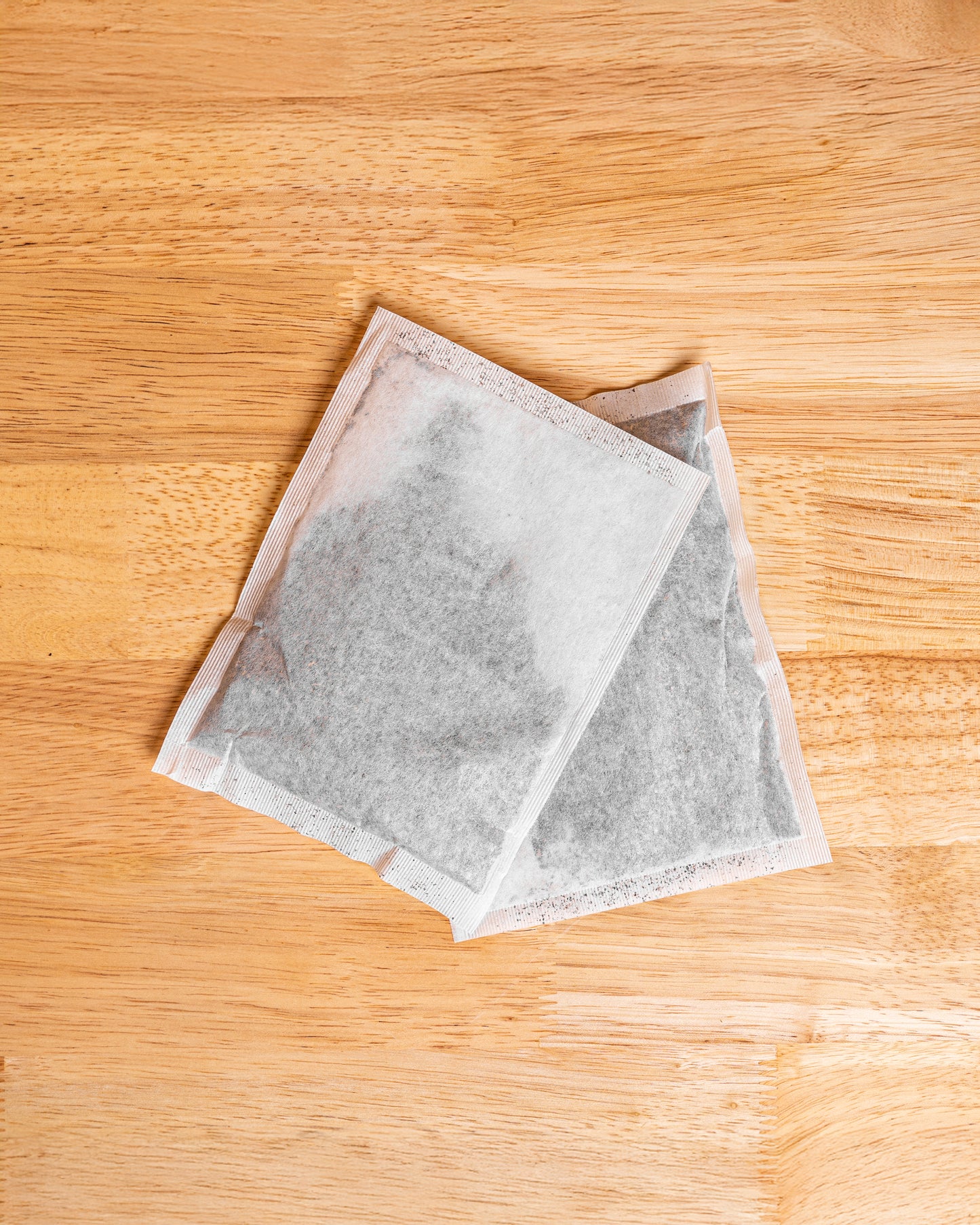 A filter pack of iced tea used for brewing fresh iced tea sitting on a wood table
