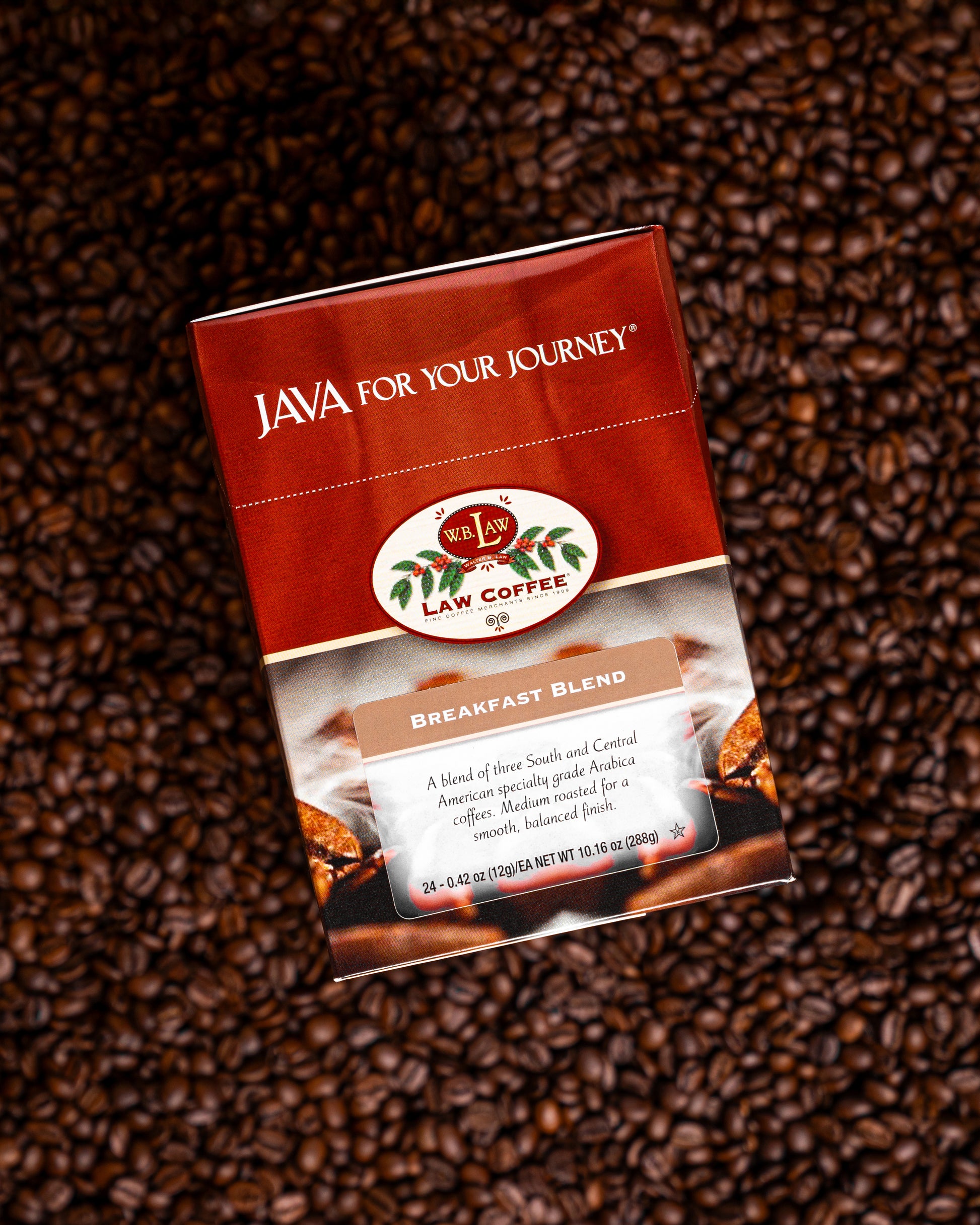 A box of breakfast blend single serve coffee cups on a background of coffee beans.