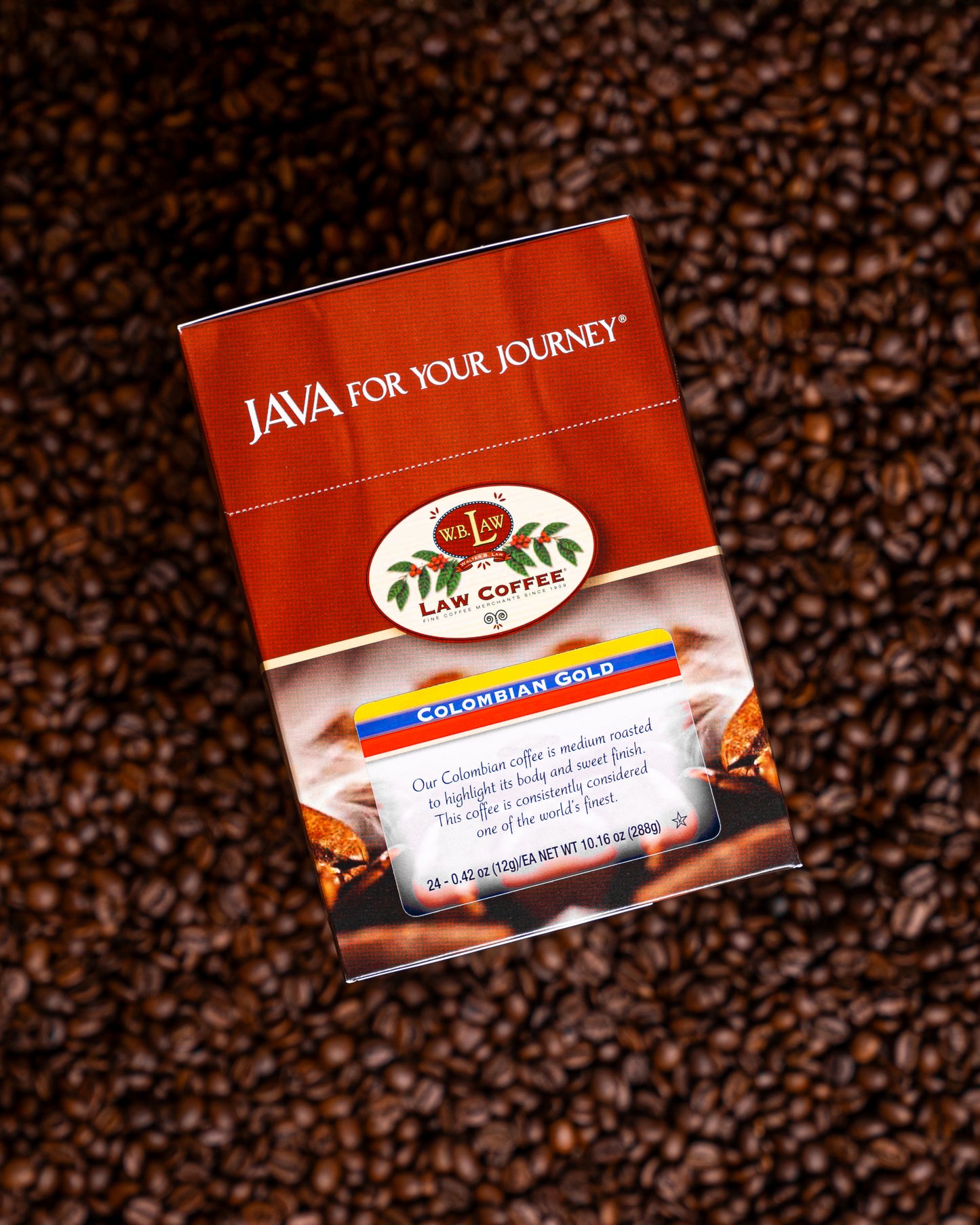 Packaging of Colombian Gold Coffee single serve cups with coffee beans in the background.