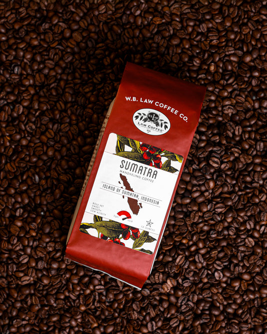 a 12oz bag of WB Law Coffee Sumatran Mandheling coffee on top of a bed of coffee beans