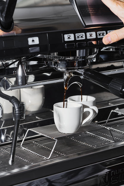 Two shots of espresso being pulled on a Nuova Simonelli espresso machine. 