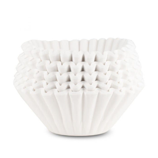 A stack of white 13x5  coffee filters used for brewing in commercial coffee brewers. 