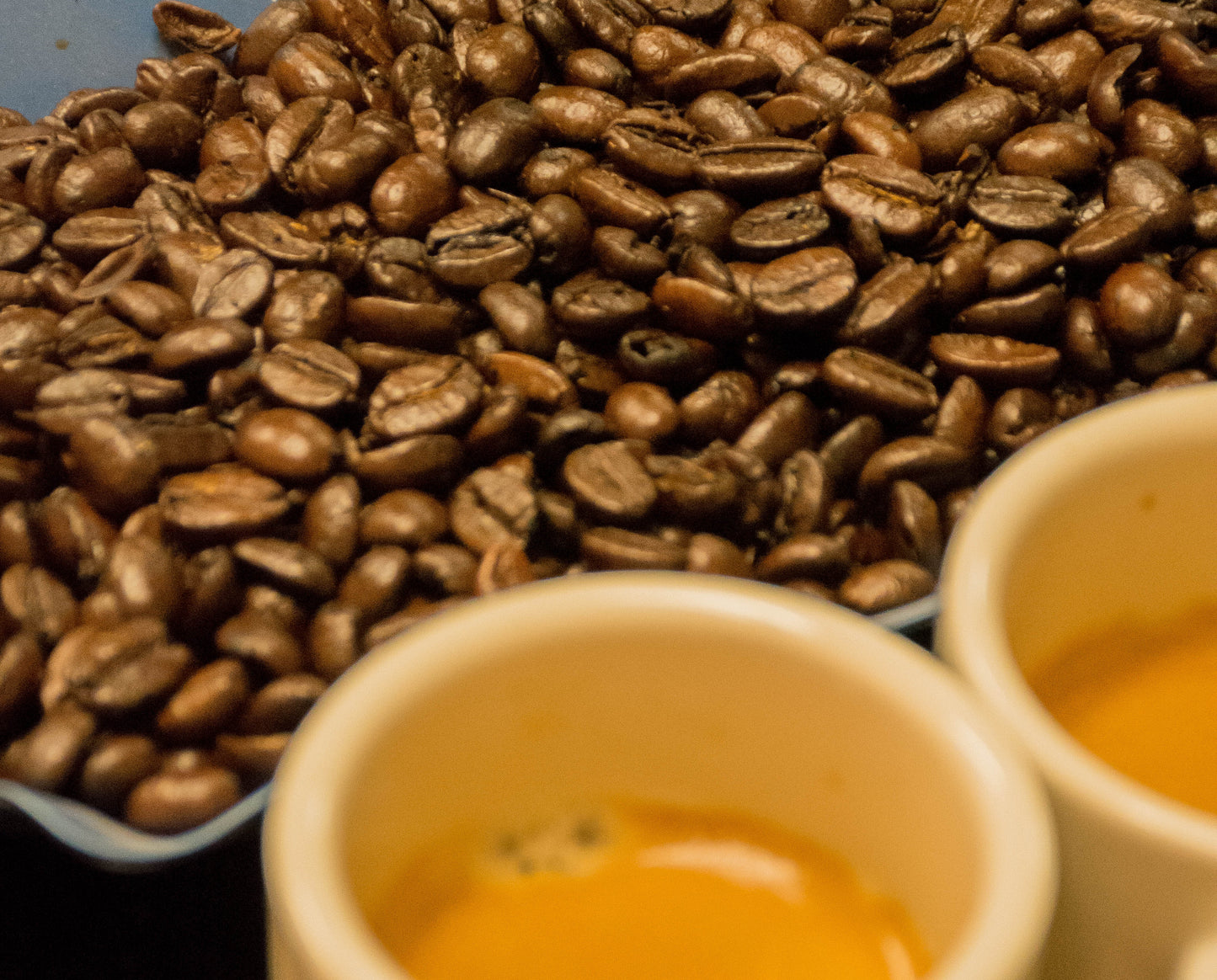 a tray of our cafe mendez espresso beans sitting next to two shots of espresso.